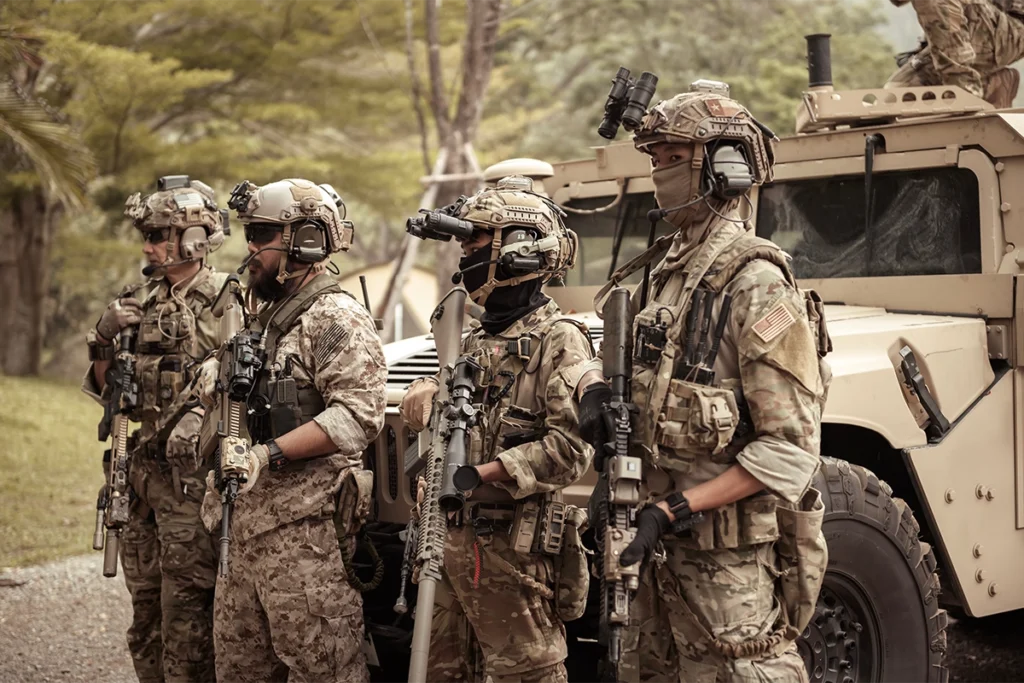Special forces soldiers in full tactical gear during an outdoor mission, equipped with night vision devices and assault rifles.