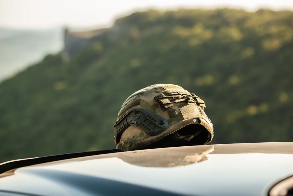 ballistic helmet in camouflage placed on top of an off-road vehicle