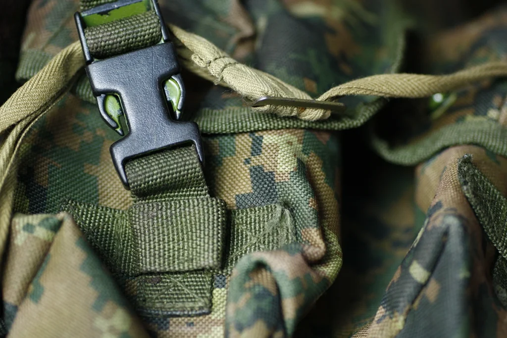 Detal oporządzenia taktycznego w kamuflażu wykonanego z materiału Cordura 500D, z widoczną klamrą