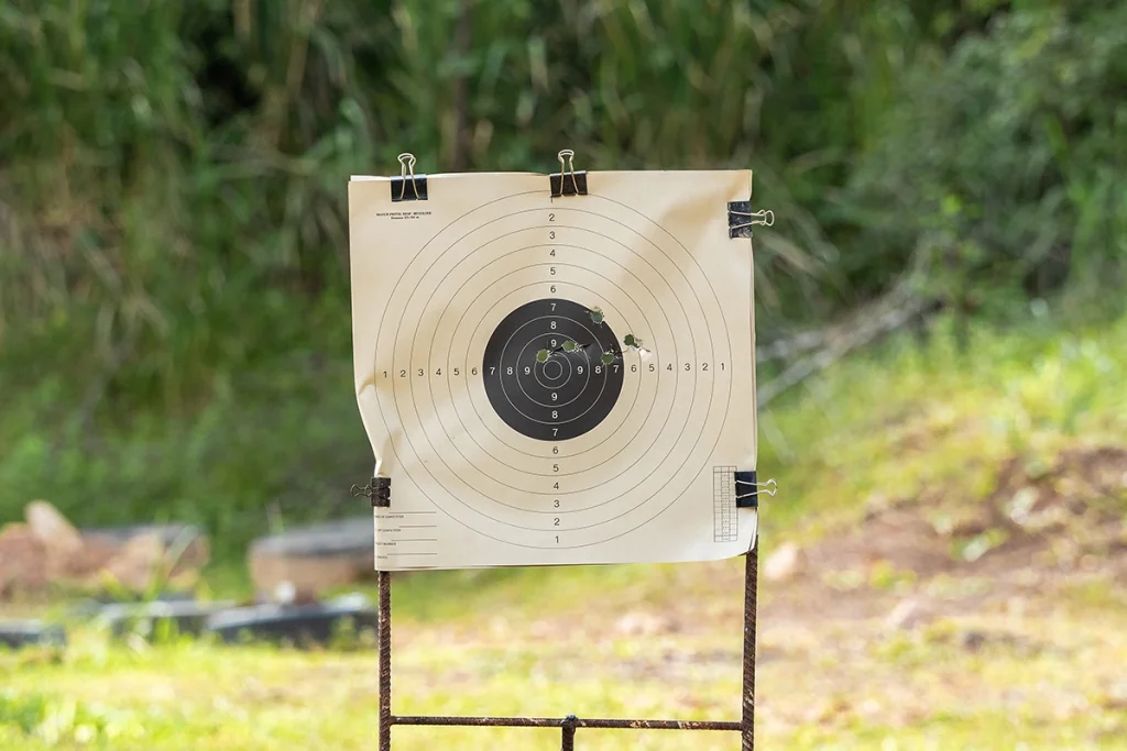 Shooting target with a tight grouping of bullet holes, confirming accuracy and zero retention after installing a red dot without milling